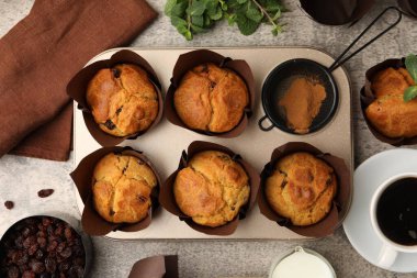 Üzümlü lezzetli kekler, nane şekeri ve kahve gri masanın üzerinde.