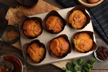 Kuru üzümlü lezzetli çörekler, nane şekeri ve ahşap masada çay, düz uzanmış