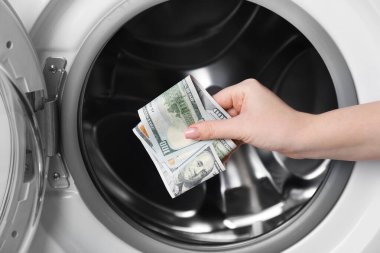 Çamaşır makinesine para koyan kadın, yakın plan.