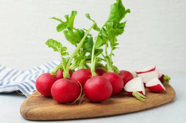 Açık gri masada yeşil yapraklı taze turplar, yakın plan.