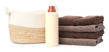 Çamaşır sepeti, havlular ve beyaza izole edilmiş bir şişe deterjan.