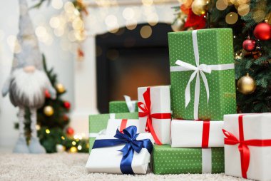 Kapalı alandaki Noel ağacının altında bir sürü hediye kutusu var. Metin için boşluk