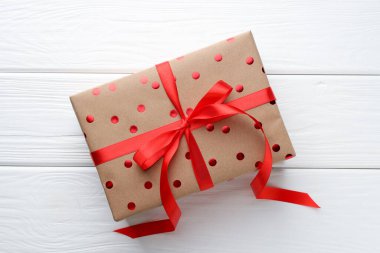 Beyaz ahşap masanın üstünde güzel bir hediye kutusu var.