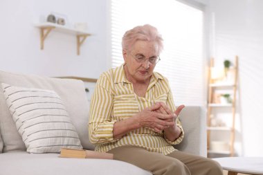 Evde avuç içi ağrısı çeken yaşlı bir kadın. Romatizma belirtileri