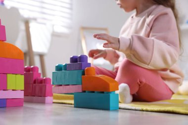 Küçük kız oyuncaklarla oynuyor oyun odasında, yakın plan.