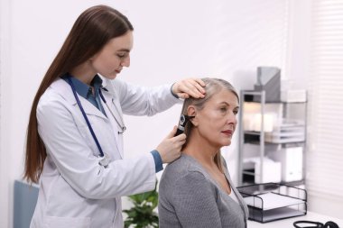 Duyma testi. Klinikte hastanın kulağını yıldız falıyla muayene eden doktor.