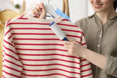 Kadın evde pamuklu bezle kazak temizliyor, yakın plan.