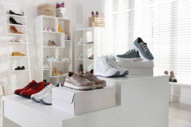 Mağazada bir sürü yeni çift ayakkabı var.