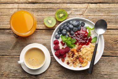 Sağlıklı kahvaltı. Fındıklı yulaf ezmesi, böğürtlen, yoğurt, kahve ve portakal suyu.