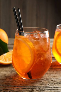 Bir bardak serinletici spritzer kokteyli ve portakallar ahşap masada, yakın plan.