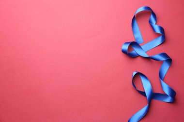 Kırmızı arka planda güzel mavi kurdele, üst manzara. Metin için boşluk