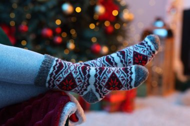 Evdeki Noel ağacının yanında rahat çorap giyen kadın, yakın plan.