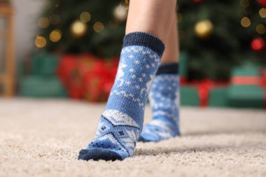 Evinde yerde mavi çoraplar giyen bir kadın, yakın plan.