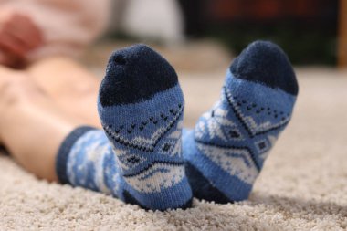 Evinde yerde mavi çoraplar giyen bir kadın, yakın plan.
