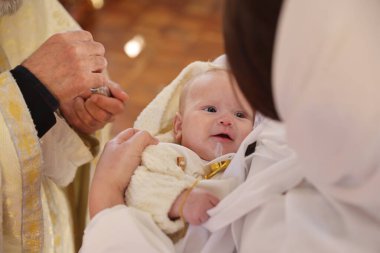 Kilisede vaftiz töreni düzenleyen rahip, yakın plan.