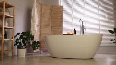 Katlanan ekran ve küveti olan şık bir banyo. Kamera ileri gidiyor