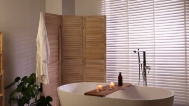 Katlanan ekran ve küveti olan şık bir banyo. Kamera ileri gidiyor