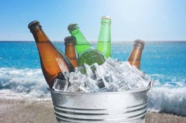 Denize yakın sahilde buzlu metal kovada bira. Tazeleyici yaz içeceği