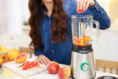 Beyaz masada blenderla nefis smoothie yapan kadın, yakın plan.