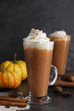 Krem şantili, baharatlı ve taze sebzeli balkabaklı latte. Koyu dokulu masa, yakın plan.