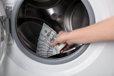 Çamaşır makinesine para koyan kadın, yakın plan.