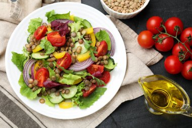 Lezzetli mercimek salatası. Gri dokuma masasında malzemeler var.
