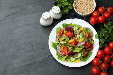 Tasty lentil salad with ingredients on grey textured table, flat lay. Space for text