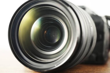 Ahşap masada profesyonel kamera lensi, yakın plan. Fotoğraf ekipmanı.