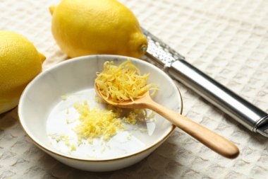 Lezzetli taze limonlar, masa örtüsü üzerinde kaşık ve rende, yakın çekim