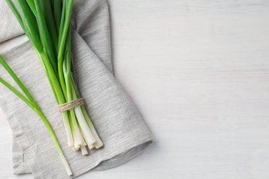 Beyaz ahşap masada taze taze taze soğanlar, üst manzara. Metin için boşluk