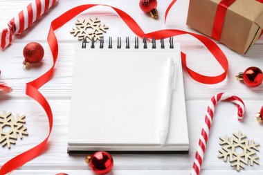 Yeni yıl hedefleri. Boş planlayıcı, kalem ve beyaz ahşap masada şenlikli bir dekor.