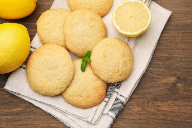 Lezzetli limonlu kurabiyeler, nane ve meyveler ahşap masada, düz yatıyordu.