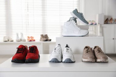 Mağazada bir sürü yeni çift ayakkabı var.