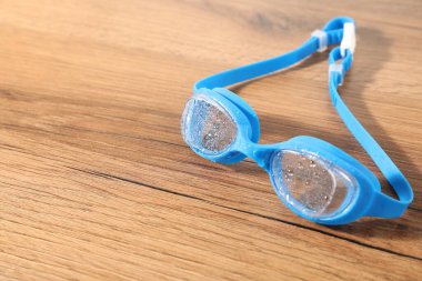 Mavi yüzme gözlükleri ahşap masada, yakın plan. Metin için boşluk