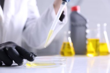 Laboratuvarda motor yağı kalitesini kontrol eden bilim adamı, yakın plan.