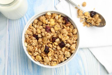 Lezzetli tahıl gevreği, kurutulmuş meyve ve süt açık mavi ahşap masa, düz uzanmış