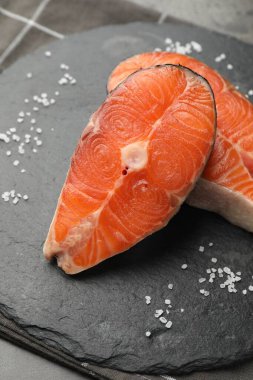 Somon fileto parçaları. Masada tuz var. Yakın plan.