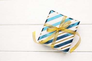 Beyaz ahşap masada güzel paketlenmiş bir hediye, üst manzara. Metin için boşluk