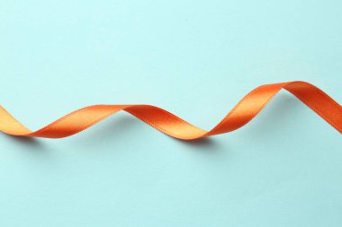Açık mavi zemin üzerinde şık turuncu kurdele, üst görünüm