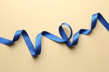 Bej arka planda stil mavisi kurdele, üst görünüm