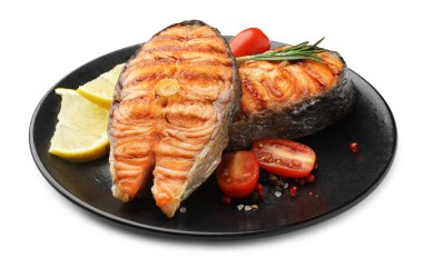 Lezzetli ızgara somon bifteği, domates, limon ve biberiye.