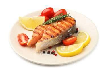 Lezzetli ızgara somon bifteği, domates, limon ve biberiye.