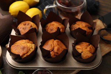 Kuru üzümlü lezzetli kekler, ahşap masada çay ve limonlar, yakın plan.