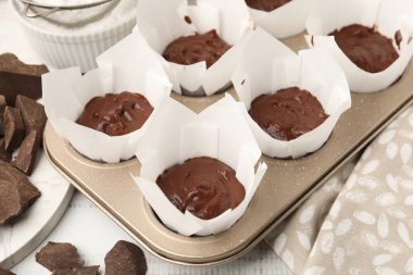 Kek tepsisinde çikolata hamuru ve masada kek malzemeleri, yakın plan.