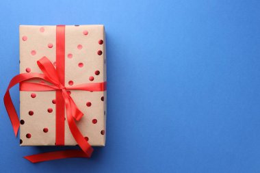 Mavi arka planda güzel bir hediye kutusu, üst manzara. Metin için boşluk