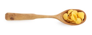 Tahta kaşıkta çiğ konchiglie makarna. Beyaz, üst manzara.