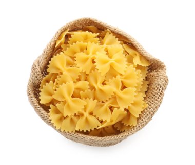 Çuvaldaki çiğ farfalle makarnası beyaza izole edilmiş, üst manzara