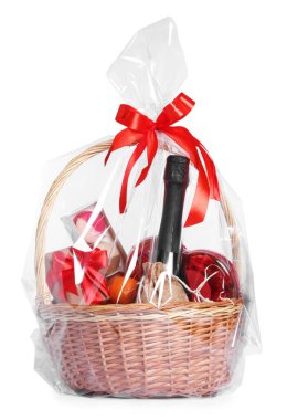 Beyaz şarap ve bir kutu şekerle dolu hasır hediye sepeti.