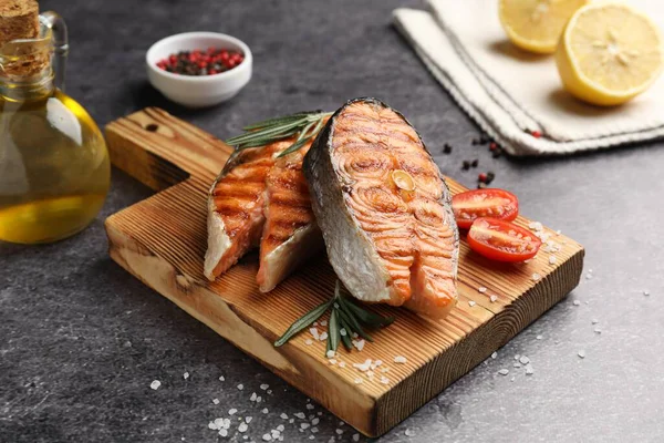 Lezzetli ızgara somon bifteği, domatesli ve biberiyeli, yakın plan.