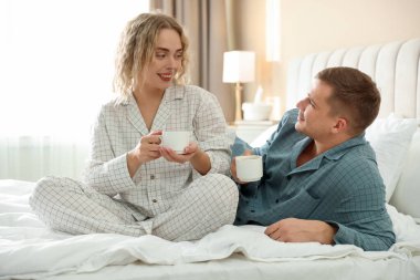 Hoş bir çift evde sıcak içeceklerin tadını çıkarıyor.